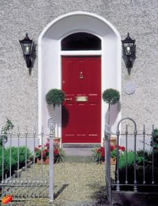 a red door on a building with a gate at Ivyleigh House in Portlaoise