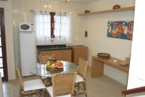 a kitchen with a table with a bowl of fruit on it at CostaSol Pipa Chalés in Pipa