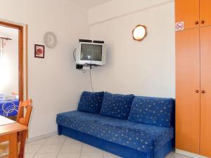 a blue couch in a living room with a tv at Apartment Radmila - MLK141 by Interhome in Gostinjac