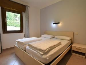 クロネにあるHoliday Home Villa Vesta-1 by Interhomeの白いシーツと窓のあるベッドのある寝室