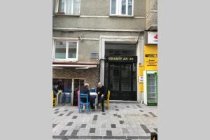 due persone sedute a un tavolo di fronte a un edificio di Cozy Apartment Next to Taksim Square a Istanbul