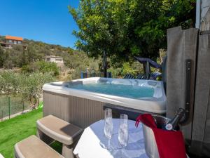 a hot tub in a backyard with a table and chairs at Holiday Home Nataly by Interhome in Vela Luka