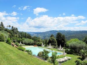 una piscina in un campo verde con montagne sullo sfondo di Holiday Home La Cupola- Girasole by Interhome a Pescia