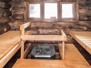 a room with two benches and a stove in a log cabin at Holiday Home Rukakämmekkä by Interhome in Ruka