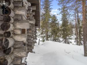 una baita di tronchi nel bosco nella neve di Holiday Home Rukakämmekkä by Interhome a Ruka