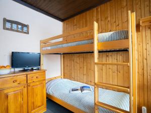 Apartment Le Sefcotel-2 by Interhome في تينيِ: غرفة نوم بسريرين بطابقين وتلفزيون