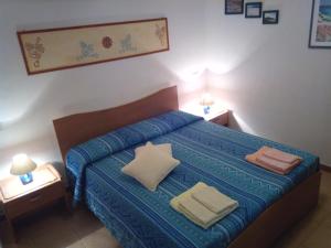 Stella Marina في كابراس: غرفة نوم بسرير ازرق مع وسادتين