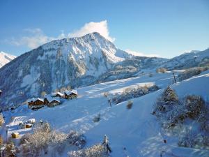 a snow covered mountain with houses on a snow covered slope at Studio Soyouz Vanguard-41 by Interhome in Le Corbier