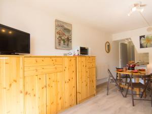 a dining room with a table and a television on a wooden cabinet at Studio Soyouz Vanguard-41 by Interhome in Le Corbier