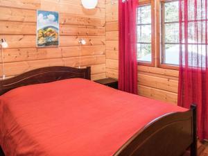 ルカにあるHoliday Home Katajarinne b by Interhomeのログキャビン内の赤いベッド付きのベッドルーム1室