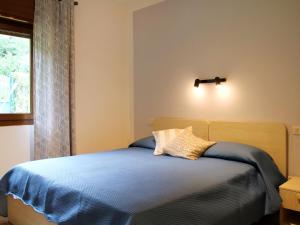 Un dormitorio con una cama con sábanas azules y una ventana. en Holiday Home Villa Vesta-3 by Interhome, en Crone