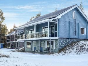 une maison bleue dans la neige dans l'établissement Holiday Home Äkäsjärven lomamökit 1 by Interhome, à Rauhala