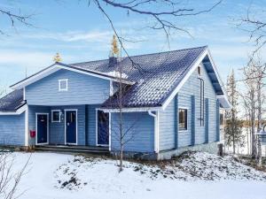 une maison bleue dans la neige dans l'établissement Holiday Home Äkäsjärven lomamökit 1 by Interhome, à Rauhala