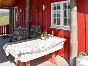 una mesa sentada fuera de un edificio rojo en Holiday Home Lenebu - FJM231 by Interhome en Syvde