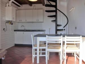 a kitchen with white cabinets and a table and chairs at Apartment Ca' Pignoi-5 by Interhome in Garda