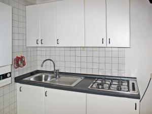 a kitchen with white cabinets and a sink at Apartment Ca' Pignoi-5 by Interhome in Garda
