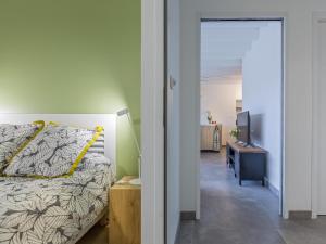 Dormitorio con cama, TV y pasillo en La Marceline gîte Confort et Nature, en Chef-Boutonne