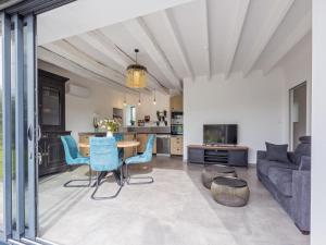 a living room with a table and blue chairs at La Marceline gîte Confort et Nature in Chef-Boutonne