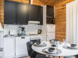ユッラスヤルヴィにあるHoliday Home Lomaylläs b39 -suppapolku 6b by Interhomeのキッチン(テーブル、椅子付)、キッチン(黒いキャビネット付)