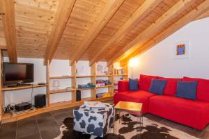 a living room with a red couch and a tv at Am Gilsbach in Adelboden