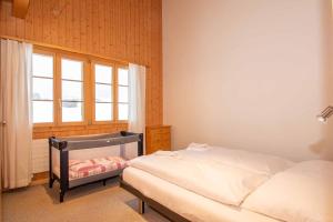a bedroom with a bed and a window at Am Gilsbach in Adelboden