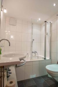 a bathroom with a sink and a tub and a toilet at Am Gilsbach in Adelboden