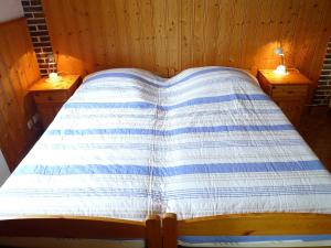 ein Bett mit einer blauen und weißen Decke drauf in der Unterkunft Apartment Krause by Interhome in Norden