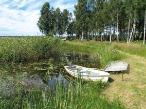 a boat sitting in the water next to a bench at Chalet Forsviken - VMD049 by Interhome in Karlstad