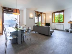 een woonkamer met een tafel en stoelen en een bank bij Holiday Home Tramonto - SEA116-1 by Interhome in Stresa