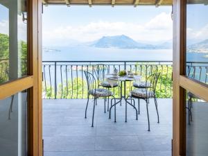 una mesa y sillas en un balcón con vistas al agua en Holiday Home Tramonto - SEA116-1 by Interhome, en Stresa