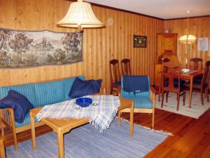 een woonkamer met een bank en een tafel bij Chalet Forsviken - VMD049 by Interhome in Karlstad