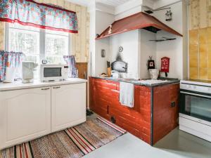 a kitchen with a stove and a microwave at Holiday Home Mäkitupa by Interhome in Laiterla