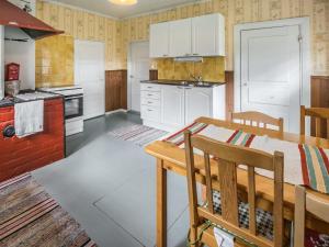 kuchnia z białymi szafkami i drewnianym stołem w obiekcie Holiday Home Mäkitupa by Interhome w mieście Laiterla