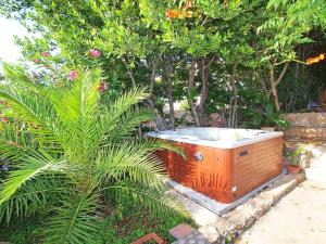 an orange hot tub in a garden with a palm tree at Holiday Home Carmen by Interhome in Ražanj