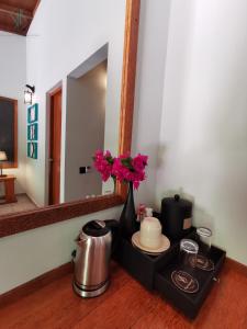 a table with a vase of flowers and a mirror at Village Hideaways & Spas in Fulhadhoo