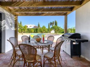 a patio with a table and chairs and a grill at Holiday Home El Torrero by Interhome in Benitachell