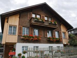 una casa con ventanas y cajas de flores. en Apartment Beatrice by Interhome, en Zweisimmen