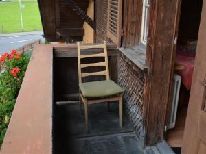 una silla sentada en el porche de una casa en Apartment Beatrice by Interhome, en Zweisimmen