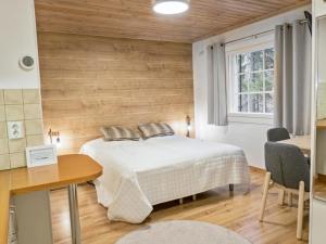 um quarto com uma cama e uma parede de madeira em Holiday Home Weekend duo by Interhome em Lahdenperä