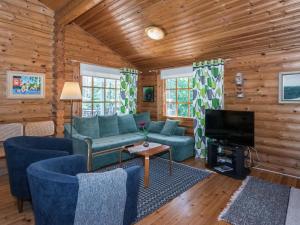 ein Wohnzimmer mit blauen Sofas und einem Fernseher in der Unterkunft Holiday Home Kiimalammi by Interhome in Niittymaa
