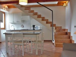 a kitchen with a table and chairs and a staircase at Apartment Ca' Pignoi-1 by Interhome in Marciaga