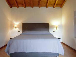 a bed in a bedroom with two lights on the wall at Apartment Ca' Pignoi-1 by Interhome in Marciaga