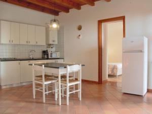 cocina con mesa, sillas y nevera en Apartment Ca' Pignoi-3 by Interhome, en Garda