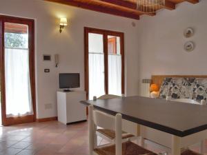 ein Wohnzimmer mit einem Tisch und einem TV in der Unterkunft Apartment Ca' Pignoi-3 by Interhome in Garda