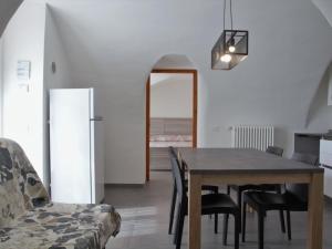 comedor con mesa, sillas y nevera en Apartment Ca' Pignoi-2 by Interhome, en Garda
