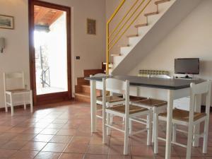 een eetkamer met een tafel en stoelen en een trap bij Apartment Ca' Pignoi-7 by Interhome in Garda