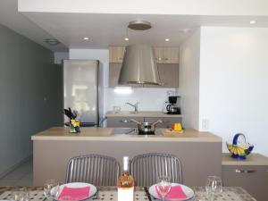 eine Küche mit einem Tisch mit 2 Stühlen und einem Waschbecken in der Unterkunft Apartment Le Myflower by Interhome in Le Grau-du-Roi