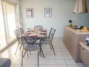 eine Küche und ein Esszimmer mit Tisch und Stühlen in der Unterkunft Apartment Le Myflower by Interhome in Le Grau-du-Roi