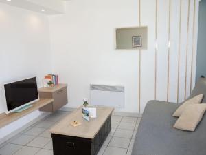 ein Wohnzimmer mit Sofa und Fernseher in der Unterkunft Apartment Le Myflower by Interhome in Le Grau-du-Roi + 15 Fotos