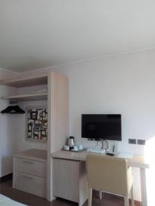 Habitación con escritorio, ordenador y TV. en Hotel Chiaraluna en Civitanova Marche